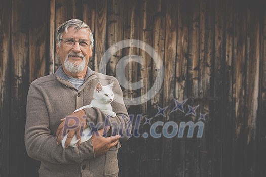 An elderly man holds a cute white kitten and smiles to the camera, selective focus, plenty of copy space An elderly man holds a cute white kitten and smiles to the camera, selective focus, plenty of copy space