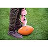 close up shot of man on the field pumping air into a professional  ball for american football