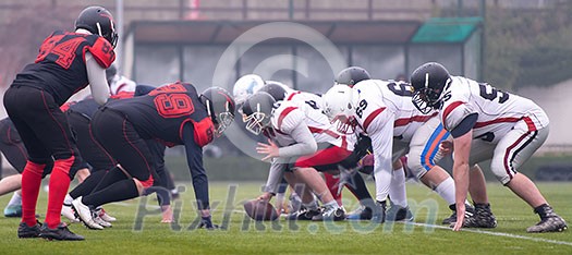 group of young professional american football players ready to start during training match on the stadium field