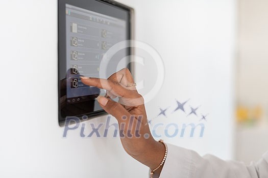 close up of hand of African woman using smart home screen control system close up of hand of African woman using smart home screen control system