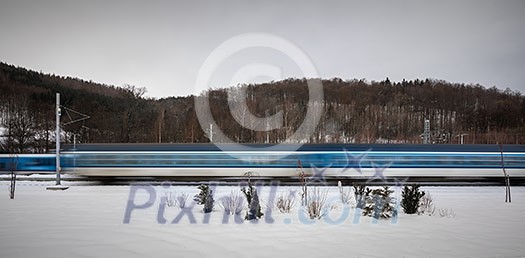 Trains going fast throught a small town train station - motion blurred image. High speed passenger train in motion. Modern intercity train. Railway transportation Trains going fast throught a small town train station - motion blurred image. High speed passenger train in motion. Modern intercity train. Railway transportation