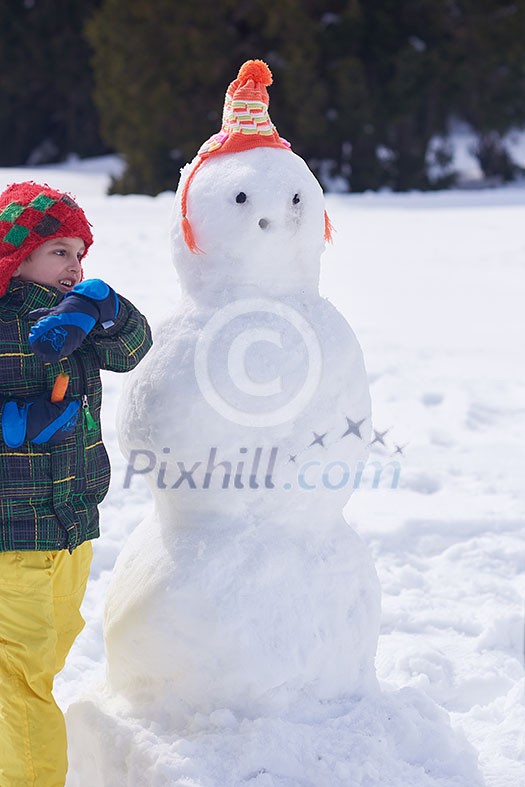 little boy making snowman