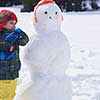 little boy making snowman