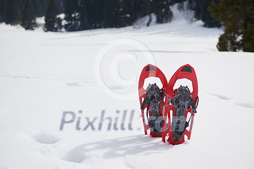 snowshoes in fresh show on beautiful winter sunny day