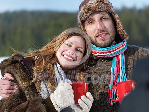portrait of happy young couple outdoor on winter day drinking warm tea with fresh snow in background portrait of happy young couple outdoor on winter day drinking warm tea with fresh snow in background
