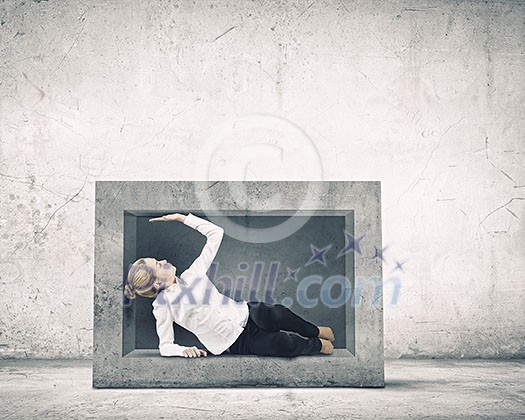 Young businesswoman trapped in stone cube in wall Young businesswoman trapped in stone cube in wall