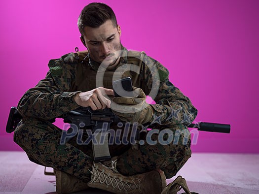 army soldier using smartphone to contact family or girlfriend communication and nostalgia concept pink background
