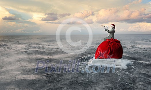 Businessman in Santa hat looking in spyglass. Mixed media Businessman in Santa hat looking in spyglass. Mixed media