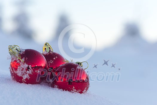 christmas red balls with long shadows  in fresh snow on beautiful sunny winter day