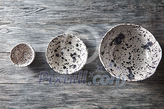 Traditional souvenir ceramic handcrafted plates and bowls on a concrete background with place under text. Flat lay. Traditional souvenir ceramic handcrafted plates and bowls on a concrete background with place under text. Flat lay.