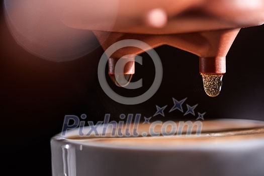 Macro photo of a coffee machine with drops of drink and a cup of freshly made coffee. Espresso Brewing Macro photo of a coffee machine with drops of drink and a cup of freshly made coffee. Espresso Brewing