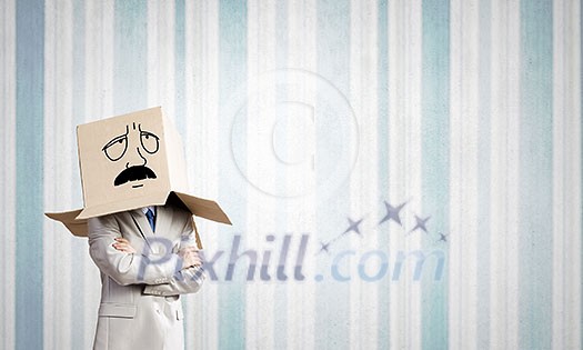 Businessman wearing carton box with drawn emotions on head Businessman wearing carton box with drawn emotions on head