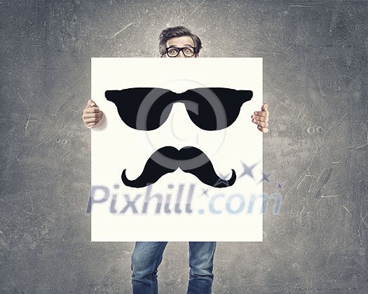 Businessman holding and hiding behind card with smiley face emoticon Businessman holding and hiding behind card with smiley face emoticon