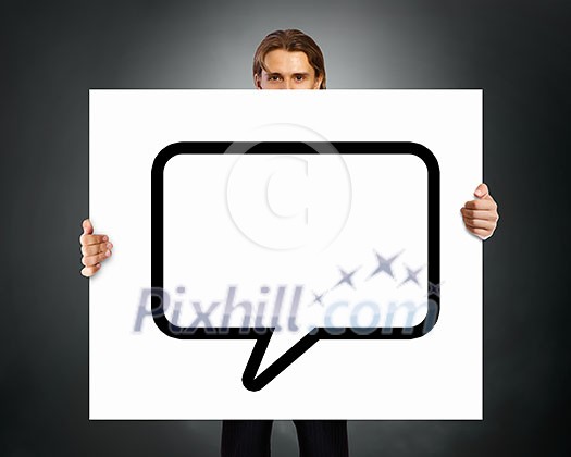 Young businessman showing blank white speech banner. Place for text