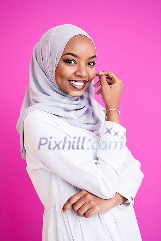 portrait of young modern muslim afro beauty wearing traditional islamic clothes on plastic pink background