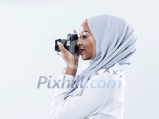 young  african modern muslim woman using retro camera wearing hijab clothes isolated on white background