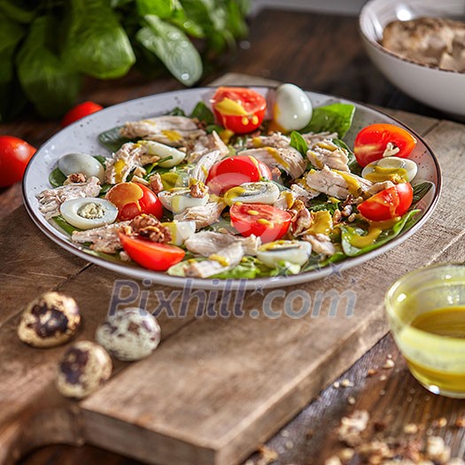 Appetizing homemade salad with fresh healthy ingredients - ripe vegetables, chicken meat in a ceramic plate with olive sause on a wooden background. Appetizing homemade salad with fresh healthy ingredients - ripe vegetables, chicken meat in a ceramic plate with olive sause on a wooden background.