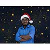 Indian man wearing traditional Santa Claus hat on chalkboard  background studio dark-skinned Christmas santa new year party night stars