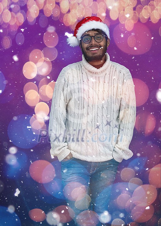 Indian man wearing traditional Santa Claus hat and white sweater  on chalkboard  background studio dark-skinned Christmas santa new year party
