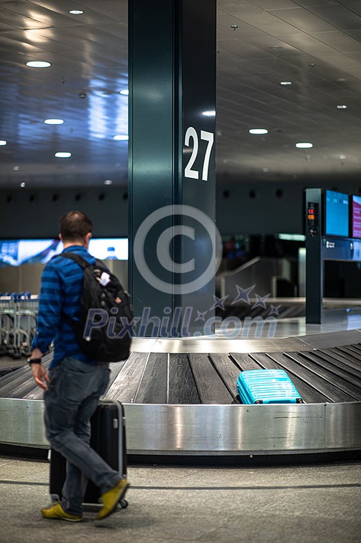 Unclaimed luggage concept - suitcase going around on the conveyor belt at an international airport, at the baggage claim zone - motion blurred image