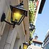 Facades of historical buildings with old-fashioned lanterns glowing of bright yelow light at italian street.