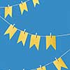 Holiday backdrop with hanging paper craft flags on a rope against blue background with copy space. Greeting card.