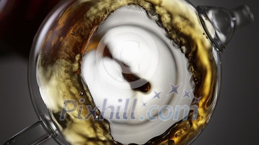 Creative looking down of pouring freshly brewed natural tea into glass teapot on a gray background. Full HD video, 240fps, 1080p. Creative looking down of pouring freshly brewed natural tea into glass teapot on a gray background. Full HD video, 240fps, 1080p.