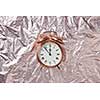 Christmas golden alarmclock on a shiny golden abstract background with copy space. The time is at five minutes to midnight. Greeting card.