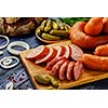 Sliced sausage on a cutting board. Smoked meat products on a wooden table. Food still life in a rustic style.