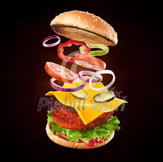 Burger with flying ingredients. Delicious monster Hamburger cheeseburger explosion concept flying ingredients.