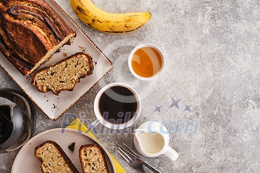 Banana bread. Freshly baked homemade banana pie with honey and butter on a light gray background. View from above.