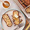 Banana bread. Freshly baked homemade banana pie with honey and butter on a light gray background. View from above.