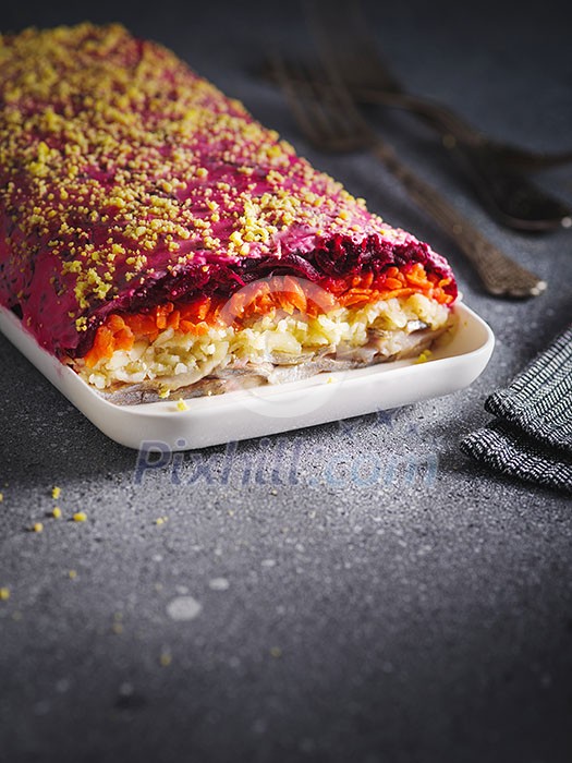 Traditional Russian salad herring under a fur coat, grey background, selective focus