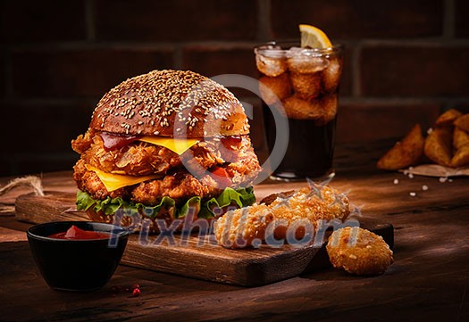 Fresh tasty homemade burger on wooden table. Big double cheddar cheeseburger with chicken cutlet with french fryes