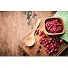 Cranberry jam in a wooden bowl on a wooden background