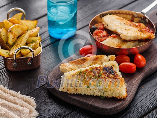 Fried fish with tomato-olive sauce and potatoes Fried fish with tomato-olive sauce and potatoes