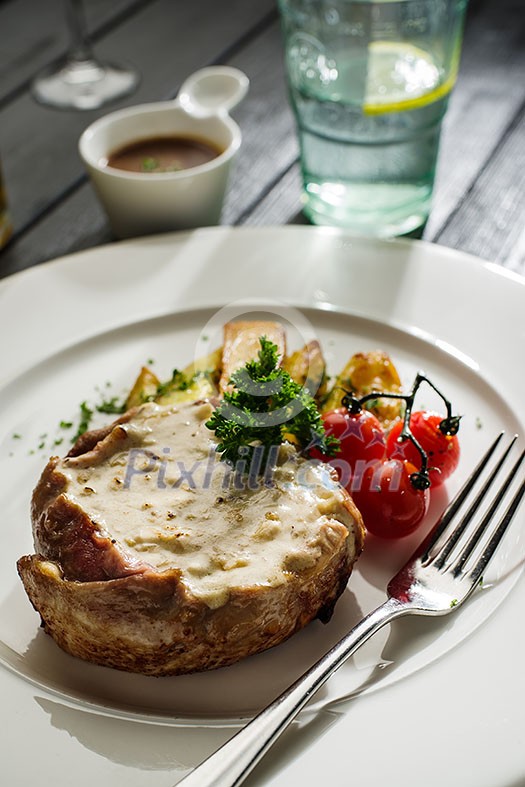 Pork with white mushroom sauce garnished with fried potatoes and cherry tomatoes Pork with white mushroom sauce garnished with fried potatoes and cherry tomatoes