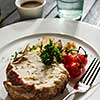 Pork with white mushroom sauce garnished with fried potatoes and cherry tomatoes