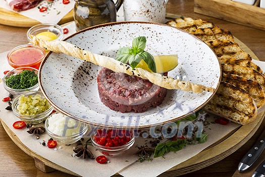 Fresh tasty beef tartare. Minced meat with ingredients for tartar.