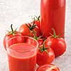 Tasty Tomato juice in a glass with ripe red tomatoes