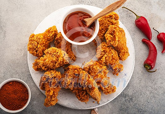 Spicy chicken wings breaded with spices and ketchup on the table, top view Spicy chicken wings breaded with spices and ketchup on the table, top view