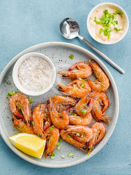 Shrimp glazed in soy sauce with green onion and lemon. Top view.