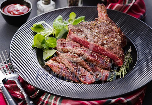 Steak on the bone. Rib eye. Tomahawk steak on the black plate with rosemary. Roasting - Rare. Entrecote. Steak on the bone. Rib eye. Tomahawk steak on the black plate with rosemary. Roasting - Rare. Entrecote.