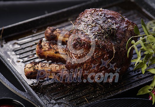 Grilled piece of meat with bone in a grill pan. Fried steak. Roasting - Medium Rare. Grilled piece of meat with bone in a grill pan. Fried steak. Roasting - Medium Rare.