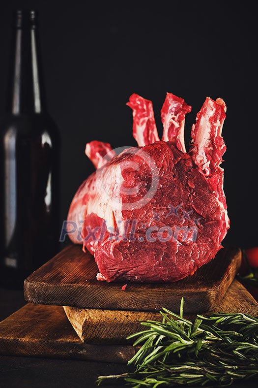 Raw beef meat on a wooden table close up on a dark background Raw beef meat on a wooden table close up on a dark background