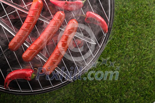 Grilled sausages on the grill. Top view. Outdoors.