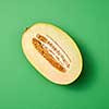 Freshly picked ripe fresh melon fruit cut on a sea green background with copy space.