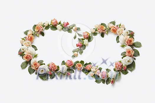 Blooming corner flowers wearth from coral roses with green leaves on a light grey background, copy space. Flat lay. Valentine's Day concept. Blooming corner flowers wearth from coral roses with green leaves on a light grey background, copy space. Flat lay. Valentine's Day concept.