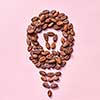 Shape of light bulb made from natural organic dry cocoa beans on a light pink background with copy space. Effect of improved human brain activity from chocolate.