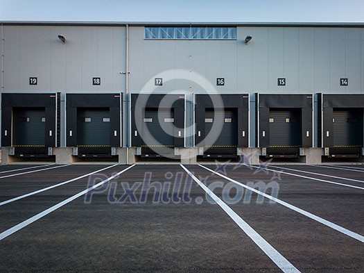 Warehouse exterior with loading ramps and slots for trucks to park - modern industry warehouse storage building. Warehouse exterior with loading ramps and slots for trucks to park - modern industry warehouse storage building.